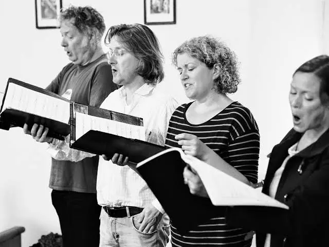 Schwarzweißbild des Ensembles Himlische Cantorey bei einer Gesangsprobe